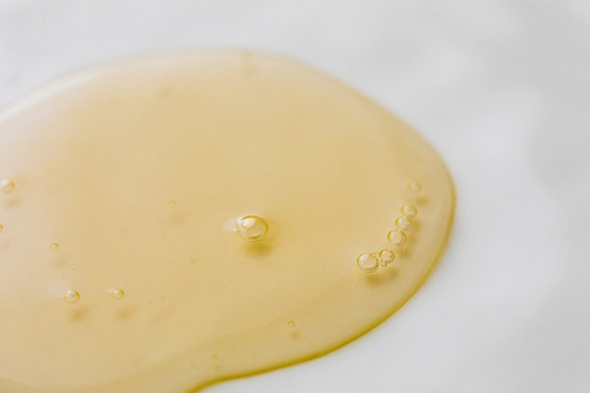 A drop of face serum on a flat surface
