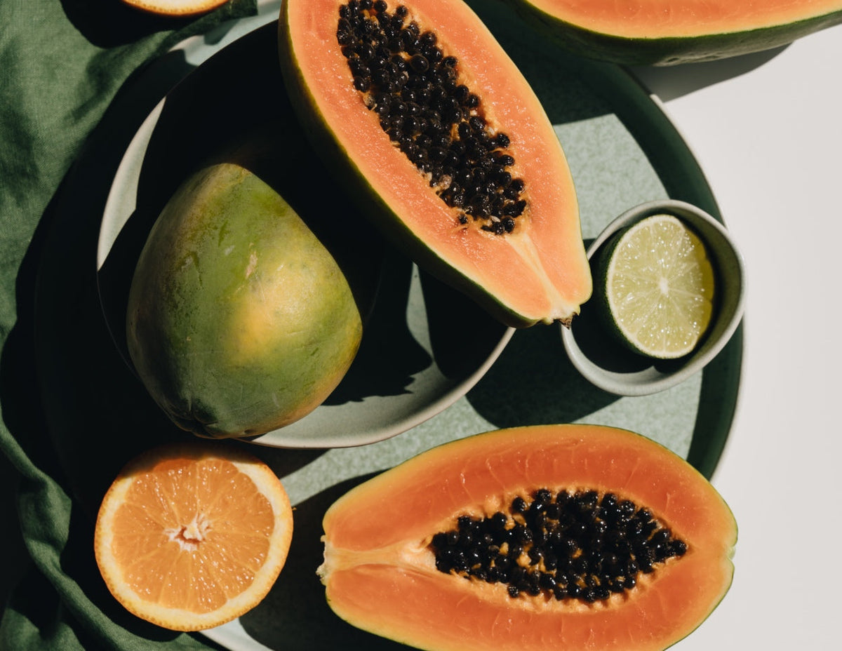 A flat lay image of papaya cut in half on a table