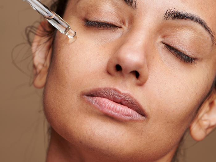 Lady applying face serum 