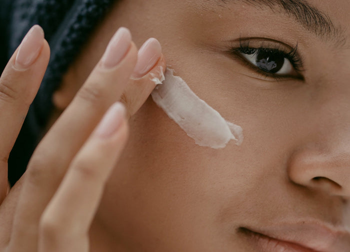 Lady applying moisturiser to her cheek bone