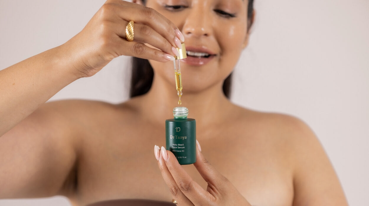 A woman holding a face serum dropper