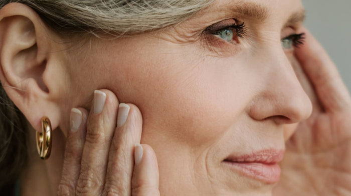 Beautiful older woman touches her face