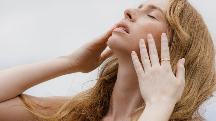 A woman with strawberry blonde hair faces the sky
