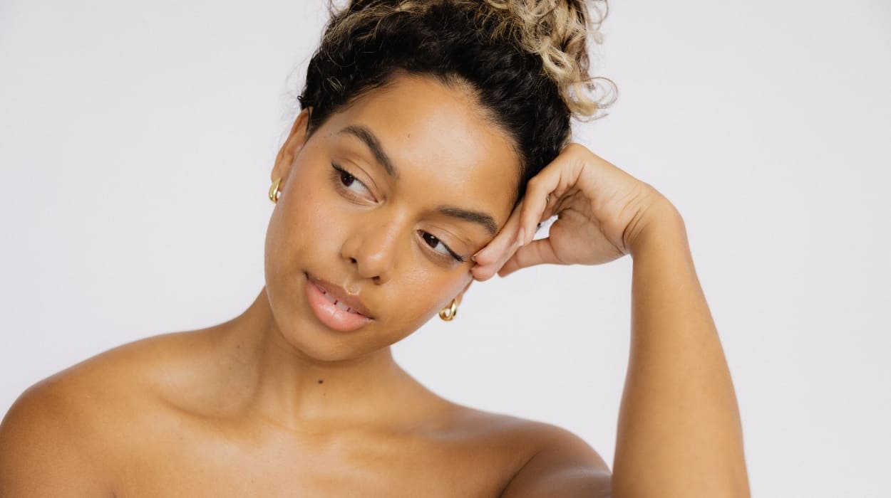 Woman with dark curly hair looks to the side