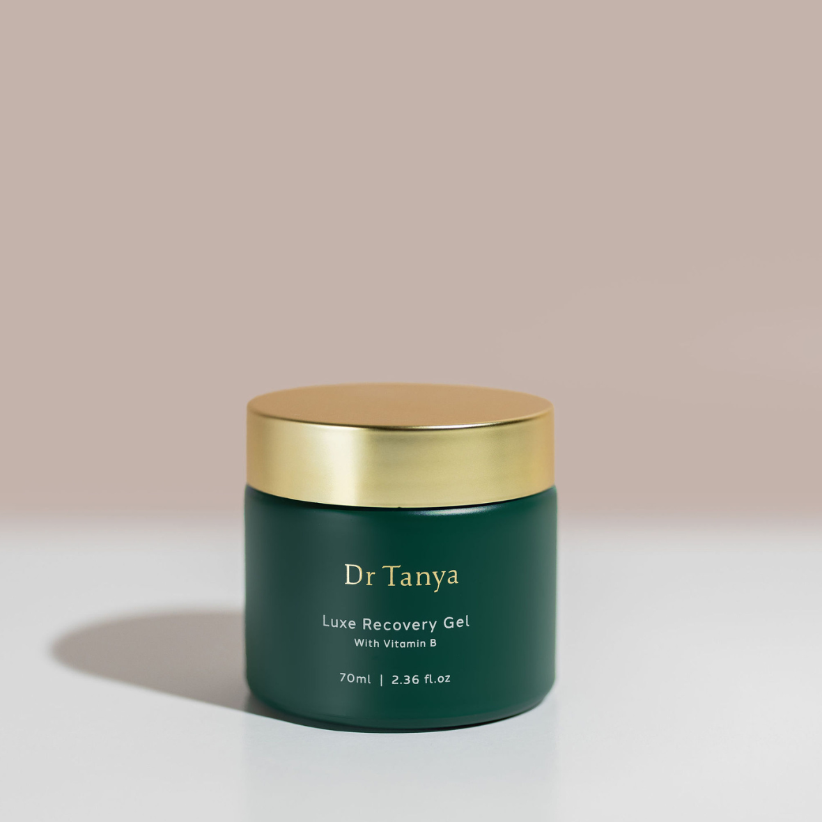 A green coloured round pot of facial skincare gel with a gold lid