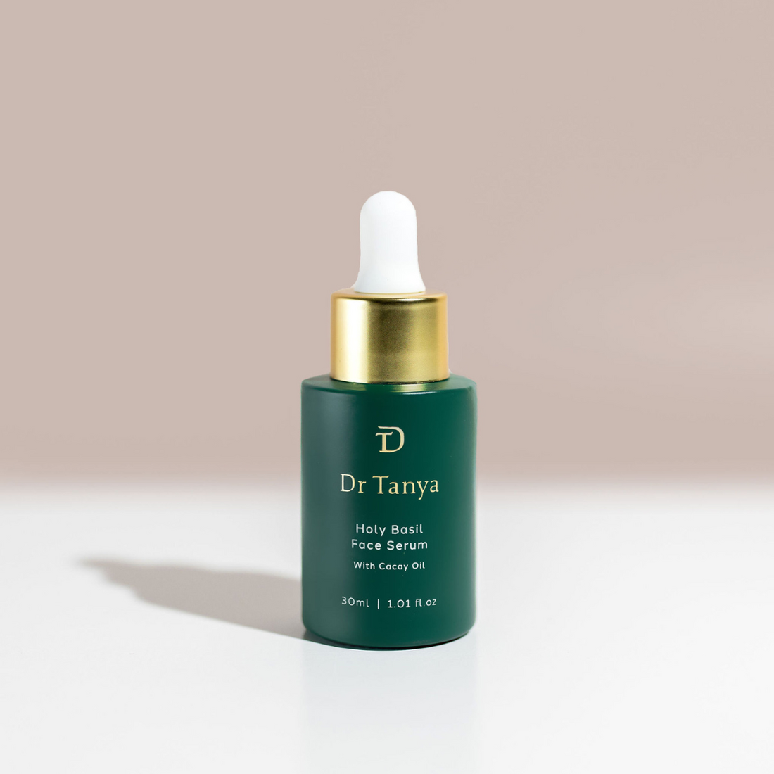 One deep green coloured bottle of face serum with a gold lid and white dropper